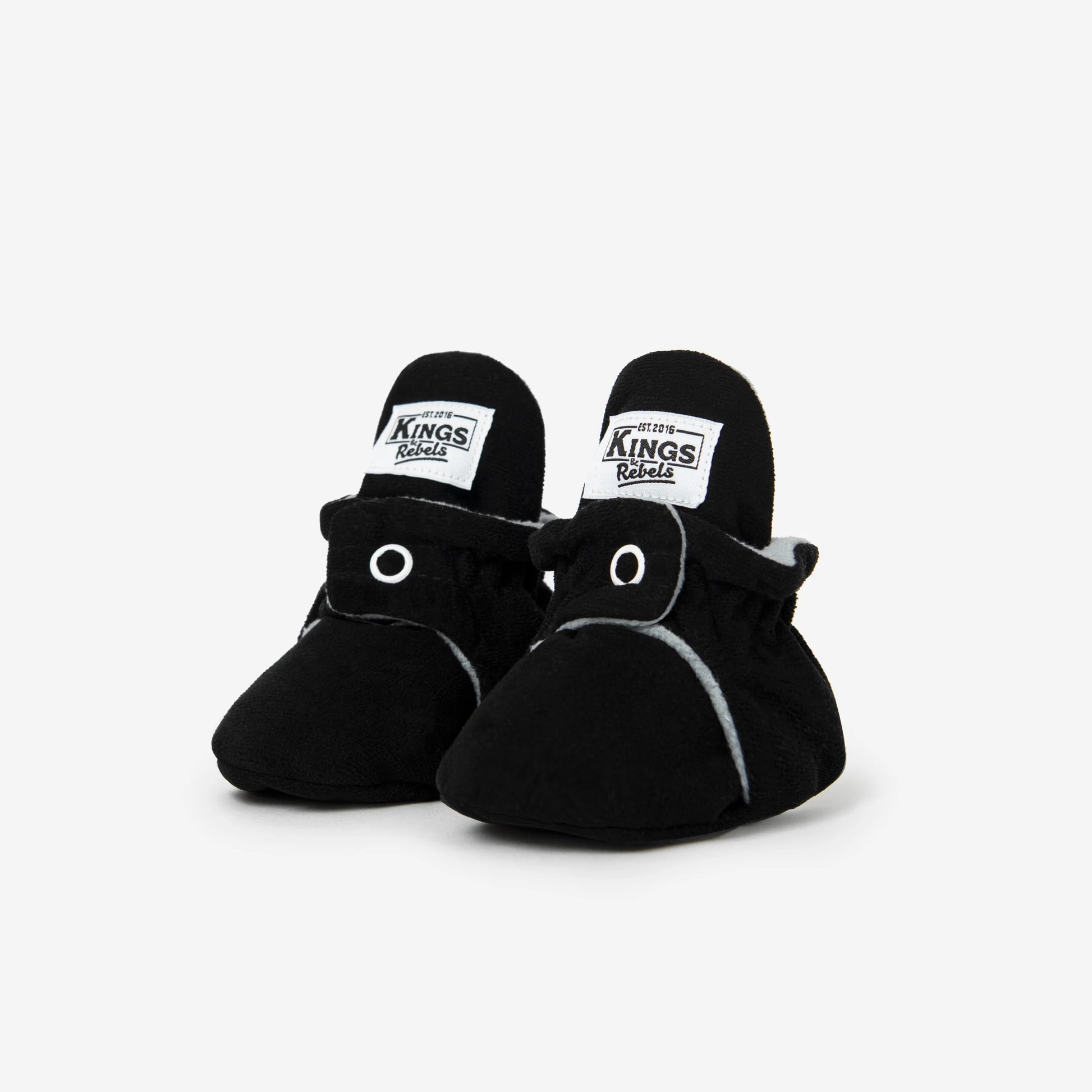 Die Kings &amp; Rebels Baby Booties wurden mit einem einfachen und praktischen Druckknopf- Verschluss entworfen, was das Anziehen von strampelnden Babys in wenigen Sekunden ermöglicht.

Der komplett um die Ferse verlaufende und über dem Knöchel sitzende, integrierte Gummizug verhindert auch bei sehr aktiven Babys das Herunterrutschen des Booties.

Die Booties passen sich perfekt an die individuelle Form der Babyfüße an und schränken somit die natürliche Entwicklung in keinster Weise ein.&nbsp;

Alle Kings &