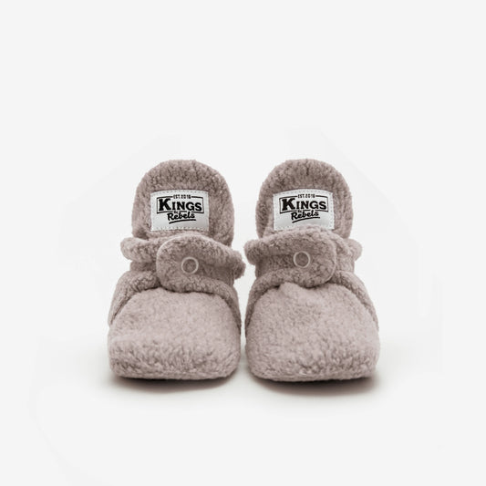 Die Kings &amp; Rebels Baby Booties wurden mit einem einfachen und praktischen Druckknopf- Verschluss entworfen, was das Anziehen von strampelnden Babys in wenigen Sekunden ermöglicht.

Der komplett um die Ferse verlaufende und über dem Knöchel sitzende, integrierte Gummizug verhindert auch bei sehr aktiven Babys das Herunterrutschen des Booties.

Die Booties passen sich perfekt an die individuelle Form der Babyfüße an und schränken somit die natürliche Entwicklung in keinster Weise ein.&nbsp;

Alle Kings &